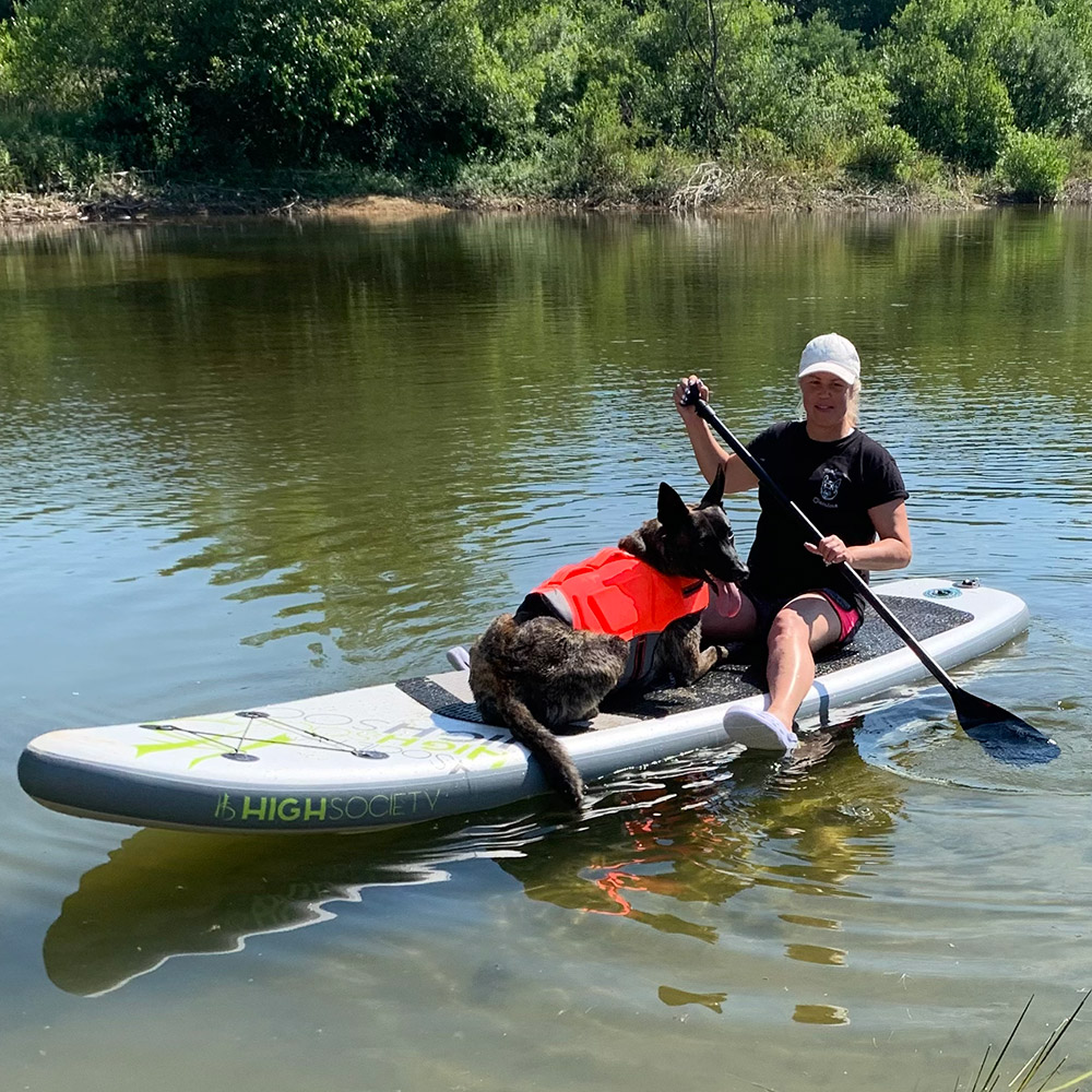 Rozalynn Parkhurst, Board & Train Programs Trainer at MDTC, paddle boarding with her dog